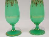 pair of green glass goblets with gold designs on them