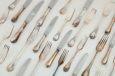 une multitude de couverts sur une table, avec des fourchettes et des couteaux