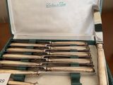 silverware in a green case sitting on a table with a price tag