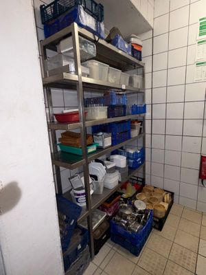 a metal shelving in the corner of a room with lots of containers