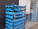 a large stack of blue pallets in a warehouse