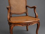 a wooden chair with wicker seat on a grey background