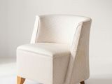 un fauteuil rembourré dans une pièce blanche aux murs blancs