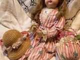 a doll that is sitting on a bed with a hat