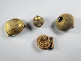 a group of five gold - plated objects including a bell, a ring, and a broochet