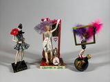 three figurines of a woman in a dress and a man in a costume