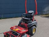 a picture of a red riding lawn mower parked in a parking lot