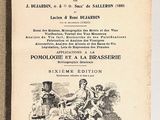 un vieux livre posé sur une table à côté d'un mur blanc