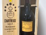une bouteille de vin dans un coffret en bois sur une table