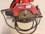 a red circular saw sitting on a white surface