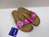 a close up of a pair of pink sandals on a white surface