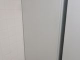 a white refrigerator in a small room with a tile floor