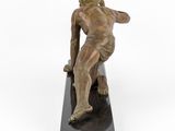 bronze statue of a man sitting on a black marble base