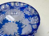 a blue glass bowl with white flowers on it