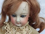 a close up of a doll with red hair and blue eyes