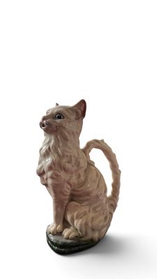 statue d'un chat assis sur un skateboard posé sur une surface blanche