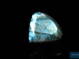 un gros plan d'une pierre de labradorite bleue sur une surface noire