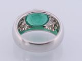 a close up of a ring with a green stone in it