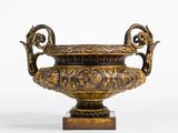 a bronze vase on a stand on a white background