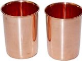deux tasses en cuivre sont posées l'une à côté de l'autre sur une surface blanche
