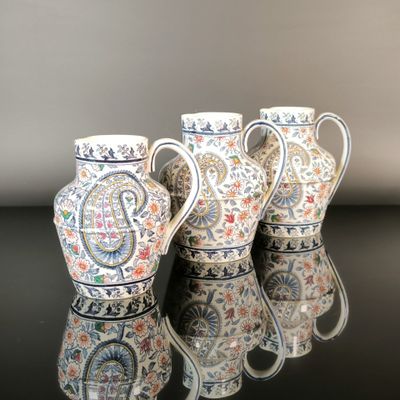 three vases are lined up on a black surface with a reflection