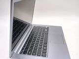a silver laptop with a black keyboard on a white surface