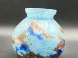a blue vase sitting on a table with a black background