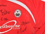 a red shirt with a lot of autographs on it