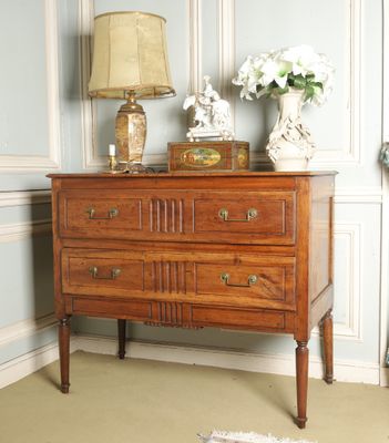 a dresser with a lamp on top of it in a room
