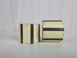 two small boxes with black and white stripes are sitting on a white surface