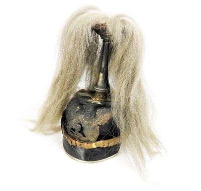 un vase noir et doré sur lequel se trouve un long cheveu blanc