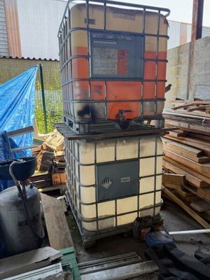 un grand conteneur métallique posé sur un tas de bois