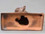 a bronze sculpture of a dog sitting on top of a box