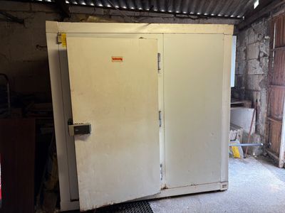 un réfrigérateur blanc dans une pièce dont la porte est ouverte