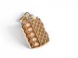 a close up of a gold pendant with pearls on a white background
