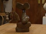 une statue représentant un oiseau perché sur une table en bois