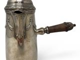 an antique silver coffee pot with a wooden handle on a white background