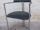a black chair with a black seat on a concrete floor