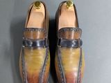 pair of brown and yellow loafers on a gray surface