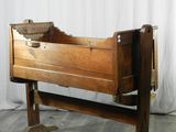 un petit berceau en bois surmonté d'un tiroir