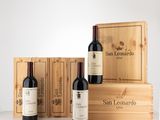 trois bouteilles de vin rouge dans un coffret en bois, à côté de deux coffrets en bois
