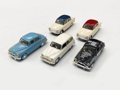 plusieurs petites voitures sont alignées sur une surface blanche