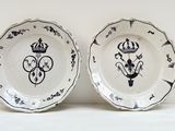 paire d'assiettes noir et blanc avec une couronne et une couronne sur les assiettes