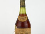 une vieille bouteille de vin posée sur une surface blanche