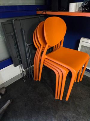 quatre chaises orange placées les unes à côté des autres dans une pièce
