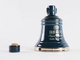 a bell that is sitting next to a bottle of beer