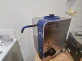 a blue and silver coffee maker sitting on a wooden table