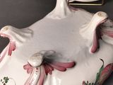 a white plate with a pink flower on it next to a white plate with a pink flower on it