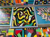 brightly colored artwork on the floor of a building with a lot of different designs