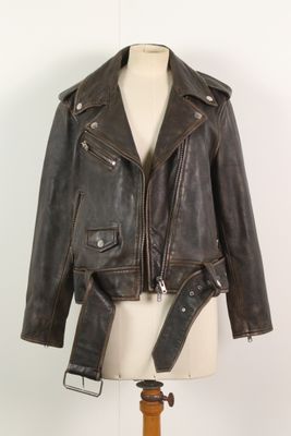 une veste en cuir posée sur un mannequin, avec une ceinture autour
